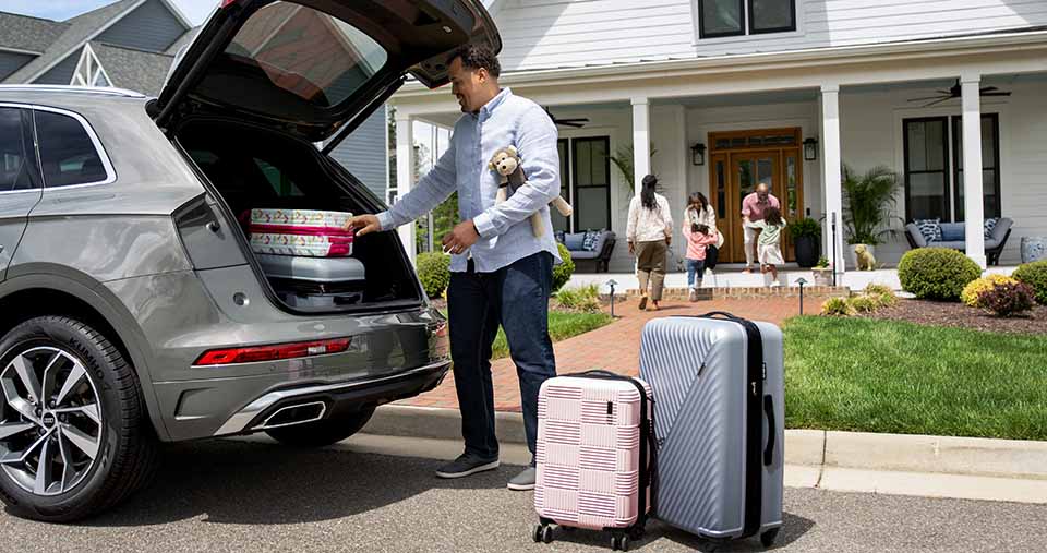 Man loading/unloading luggage from the spacious rear cabin of the Audi Q5