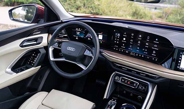 Driver's view of the 2025 Audi Q5 interior with digital cockpit, multifunction steering wheel, and MMI touchscreen display.