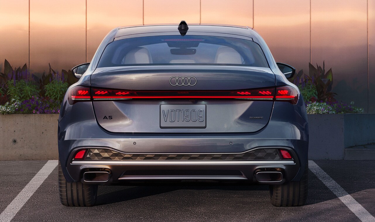 Rear view of the 2025 Audi A5 with LED taillights, dual exhaust outlets, and quattro badging.