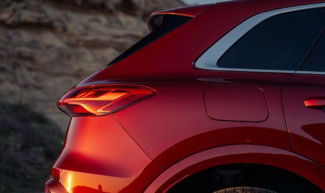 Rear view of the 2025 Audi Q5 highlighting the LED taillights and sleek red exterior design.