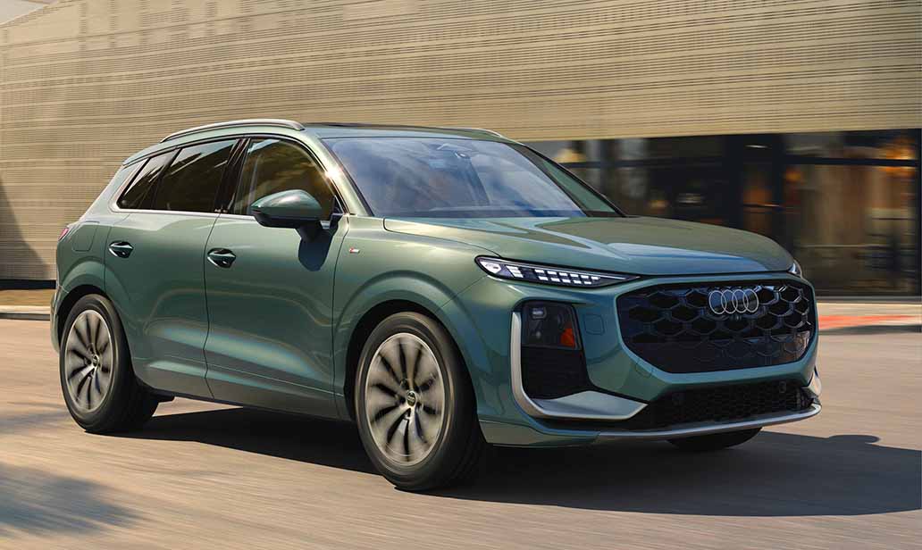 2026 Audi Q3 in metallic green driving past a modern building, showcasing sleek LED headlights, aggressive front fascia, and aerodynamic styling.