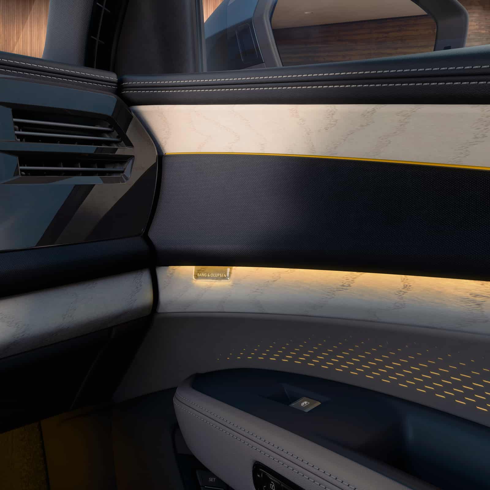 2027 Audi Q9 door panel with wood inlay, ambient lighting, and a Bang & Olufsen speaker grille
