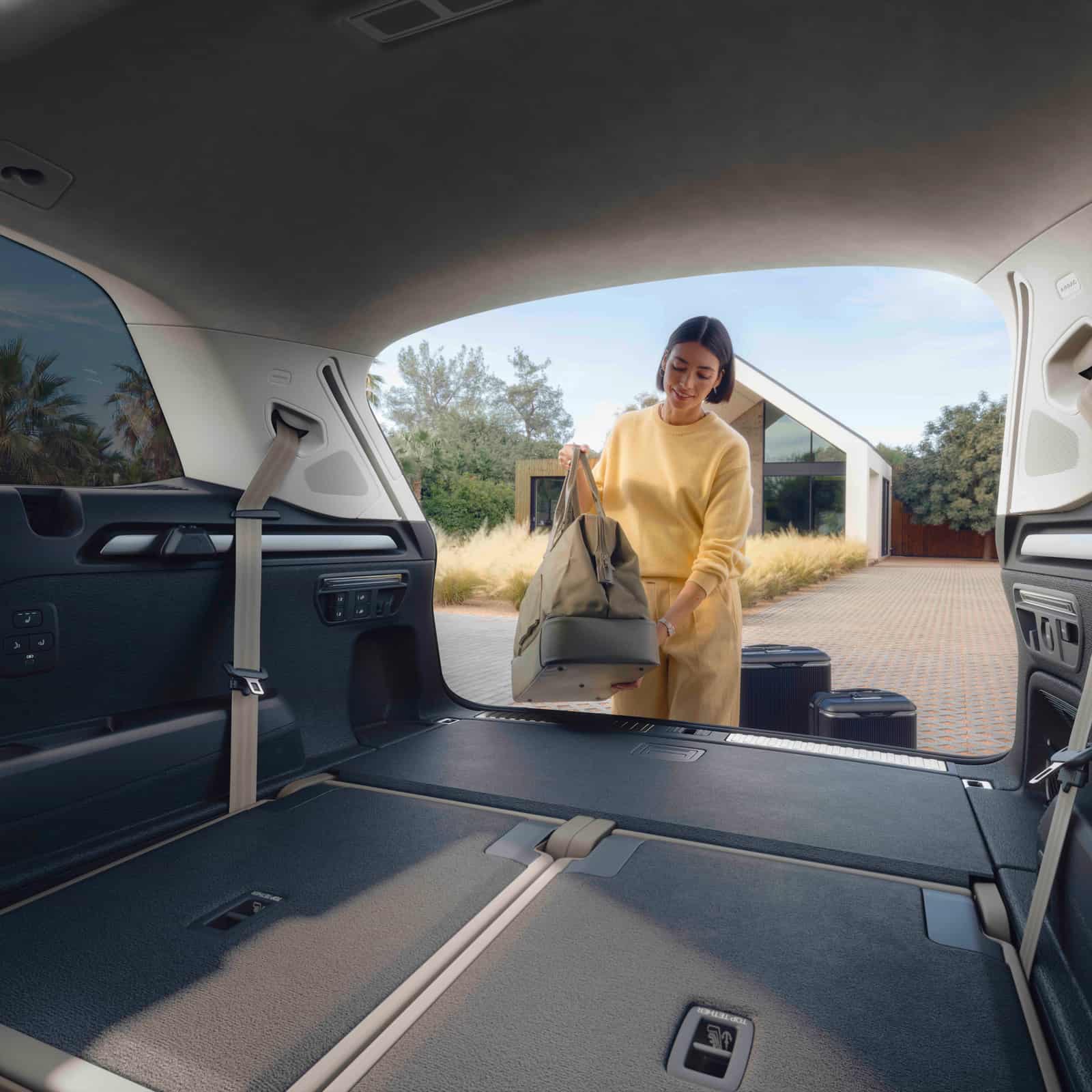 2027 Audi Q7 open cargo area with a passenger loading a bag