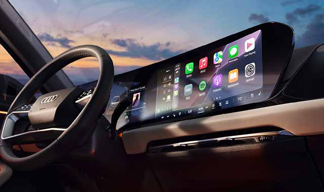 Driver’s cockpit of the 2025 Audi A5 with a seamless digital display, showcasing Apple CarPlay, navigation, and modern infotainment controls.