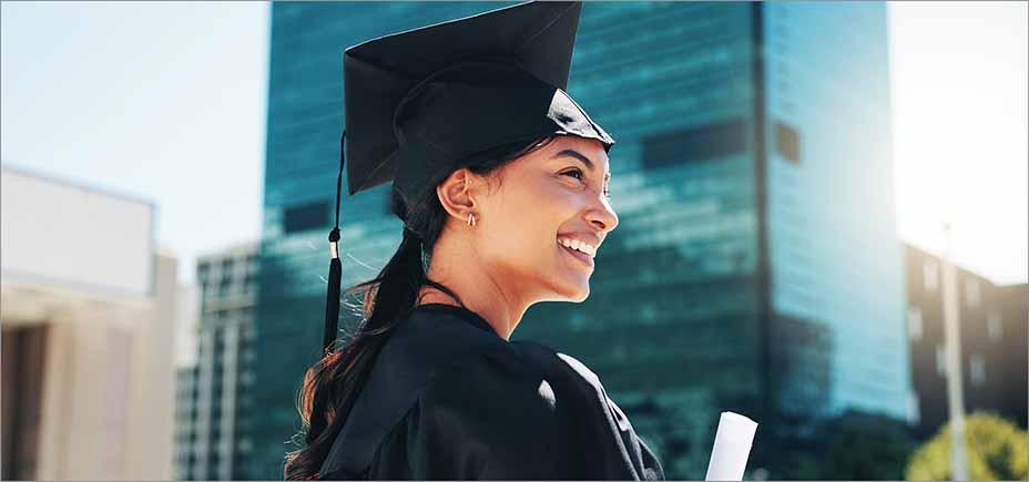 College graduate in cap and gown holding a diploma