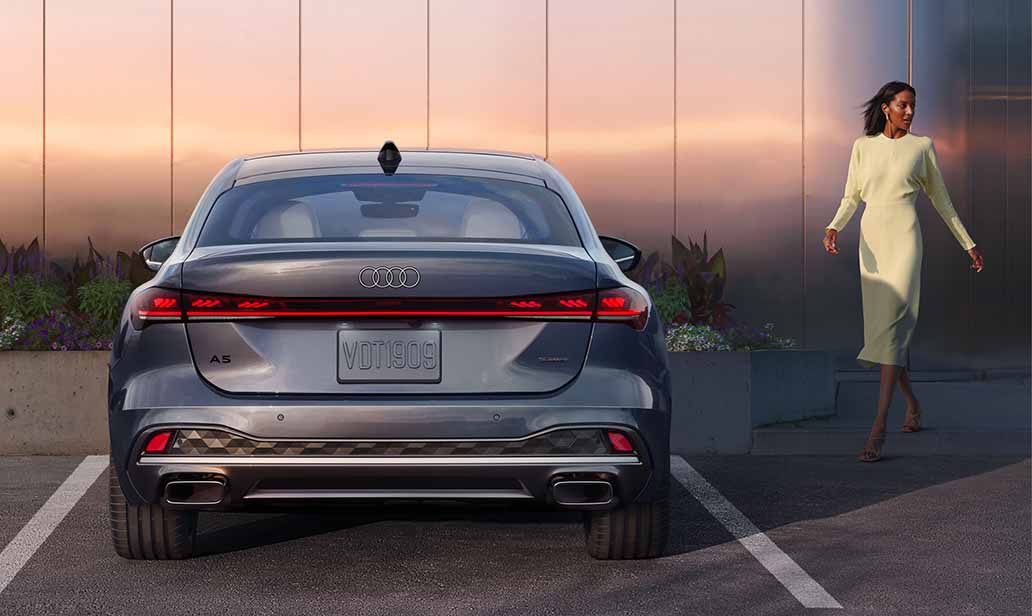 Woman walking towards a parked 2025 all-new Audi A5