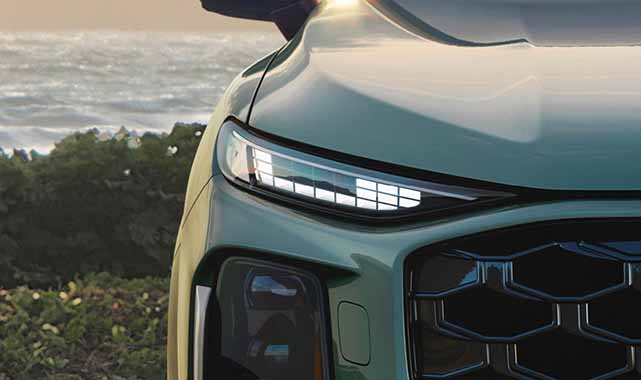 Audi Q3's front LED headlight and sculpted hood.