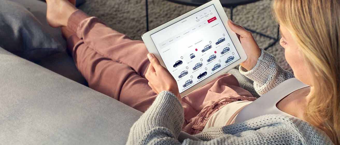 Woman on sofa using ipad to search payment options