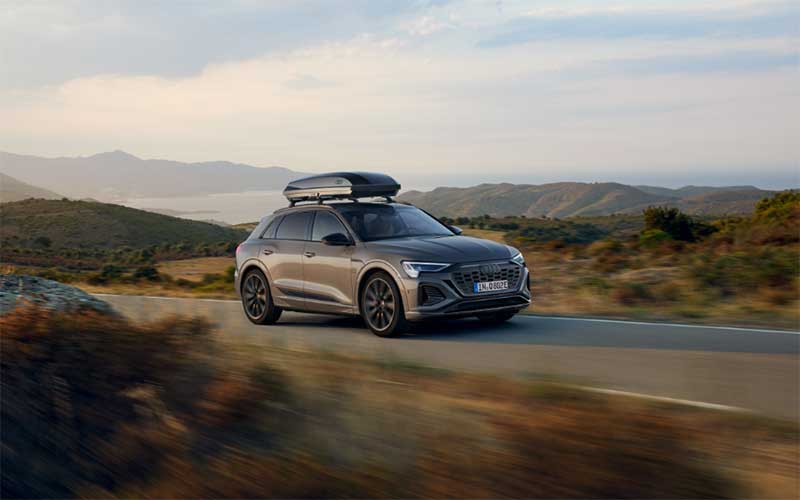 Audi with Roof Box driving on a road