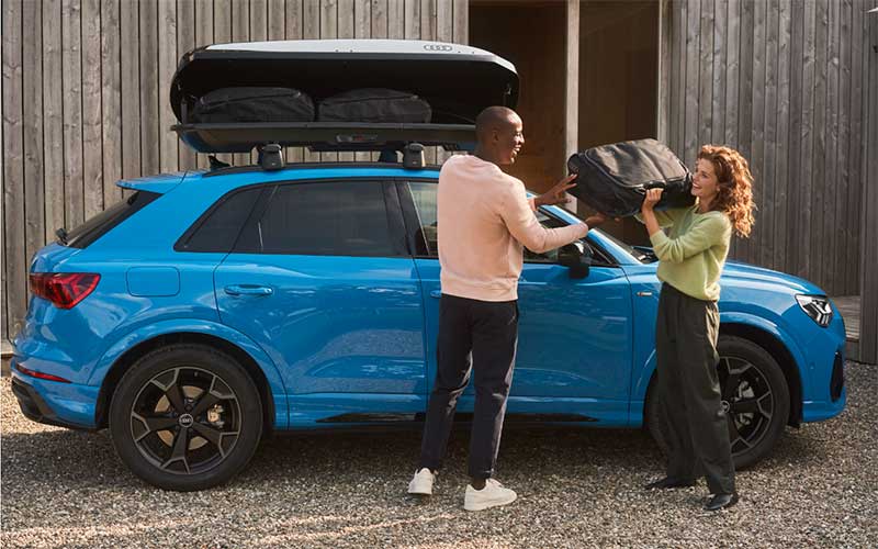 Man and woman loading a roof box on an Audi