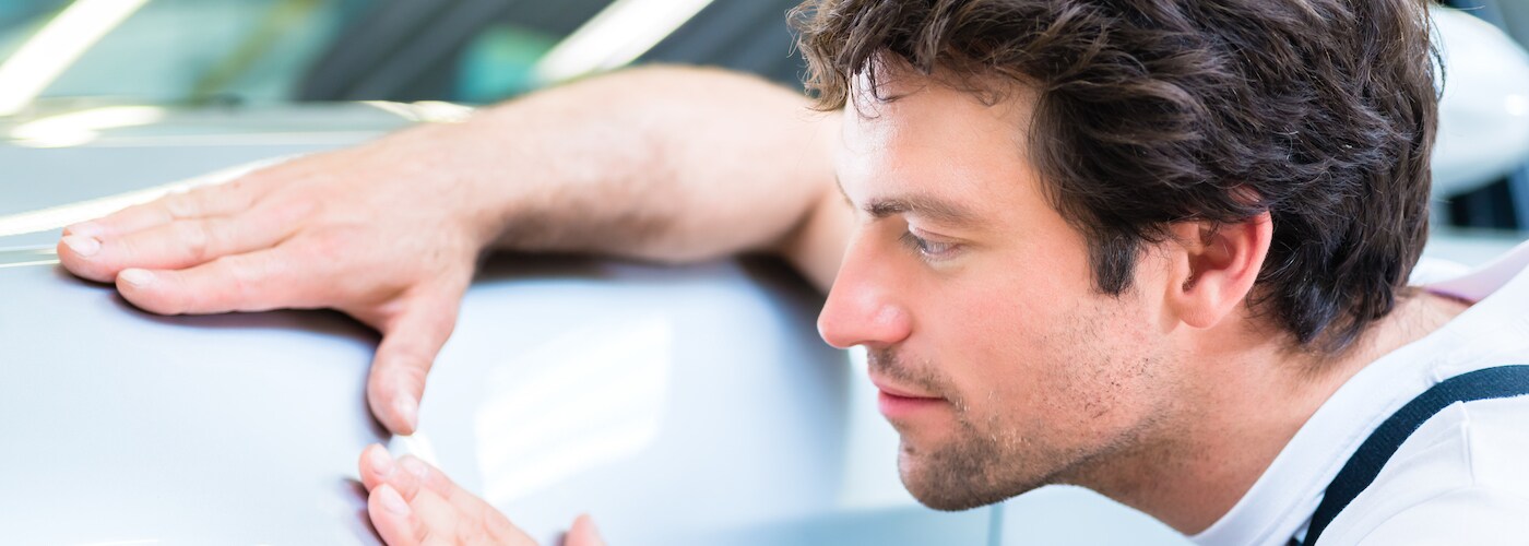 Man Examining Car Dent