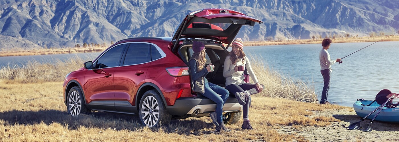 Friends sitting in back of Ford Escape by lake