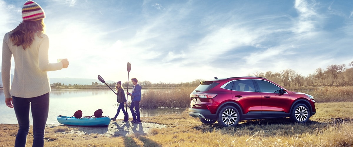 Ford Escape Parked by Lake with People and Canoe