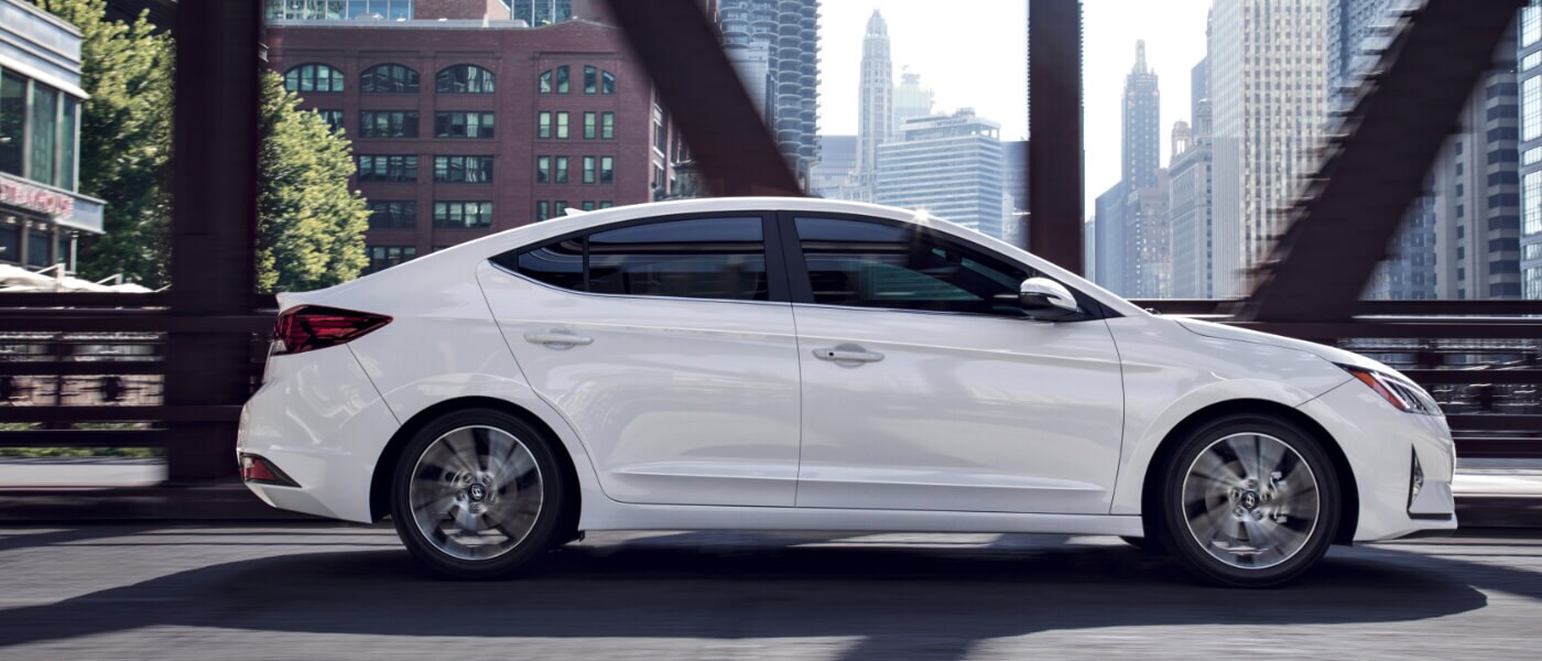 2020 Hyundai Elantra in white side view driving on a bridge in a city