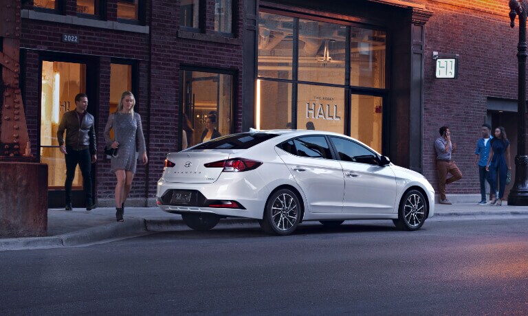 Couple walking to a white 2020 Hyundai Elantra parked on the street