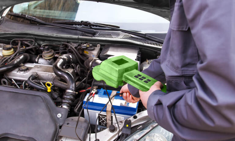 Technician testing car battery