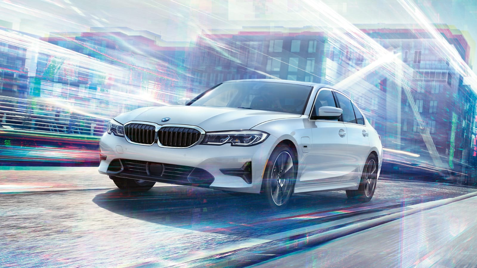 White BMW 3 series driving in colorful city streets.