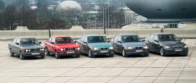 BMW generations of 3 Series parked in a line.