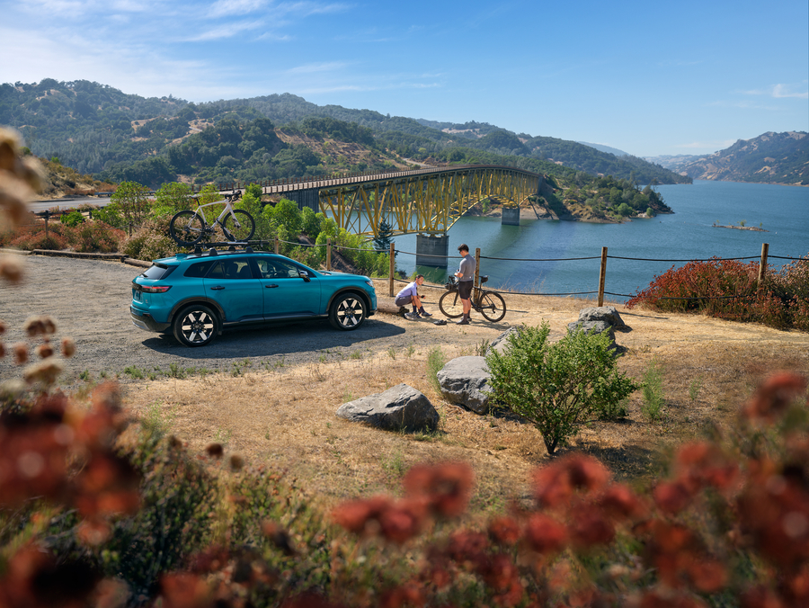 Honda Prologue parked by a cliff with people on their bikes standing outside