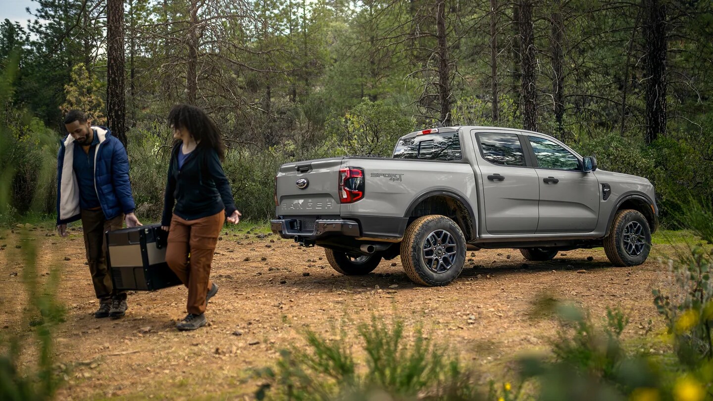 An image showing two campers unloading a Ford Ranger