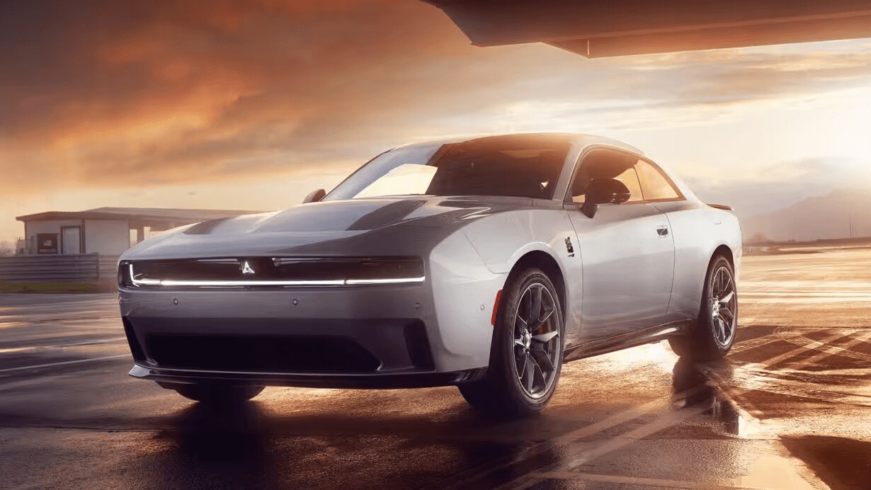 Learn about the specs and features of the 2025 Dodge Charger Daytona EV An exterior shot of a Dodge Charger Daytona parked outside a sunset scene