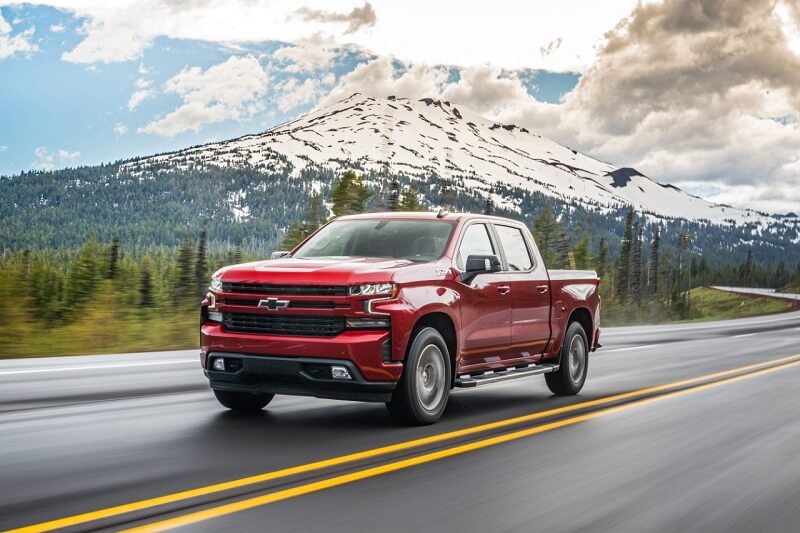 Learn more about the Buick/GMC/Chevrolet CPO Program Image of a red GMC pickup driving down the highway