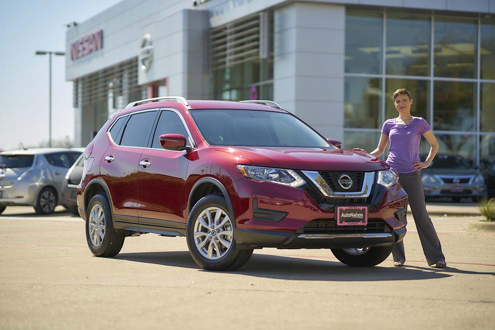Watch car research videos on AutoNation Drive Image of woman standing next to new car