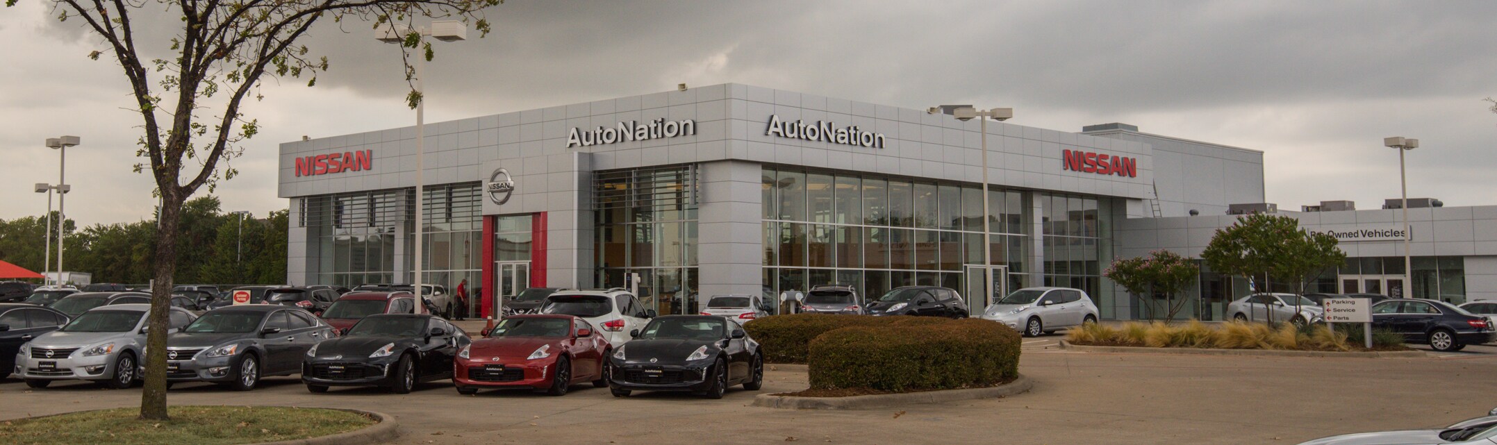 Exterior entrance to AutoNation Nissan Lewisville dealer during the day