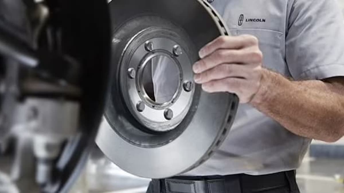 Lincoln service technician holding a brake disc