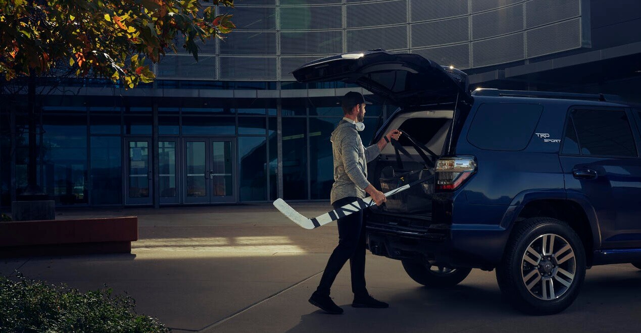 Build and price your 2023 Toyota 4Runner man putting hockey equipment inside Toyota 4runner