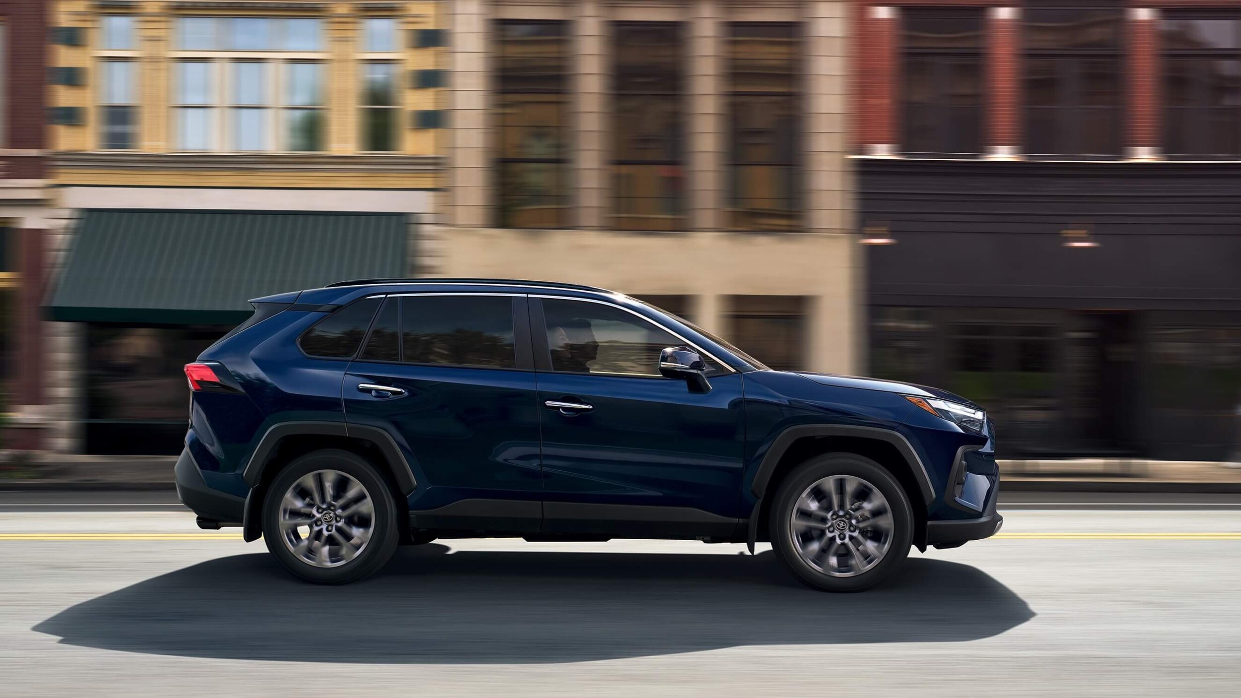 Learn about the fuel efficiency of the Toyota RAV SUV Exterior shot of a Toyota RAV4 SUV driving down a road