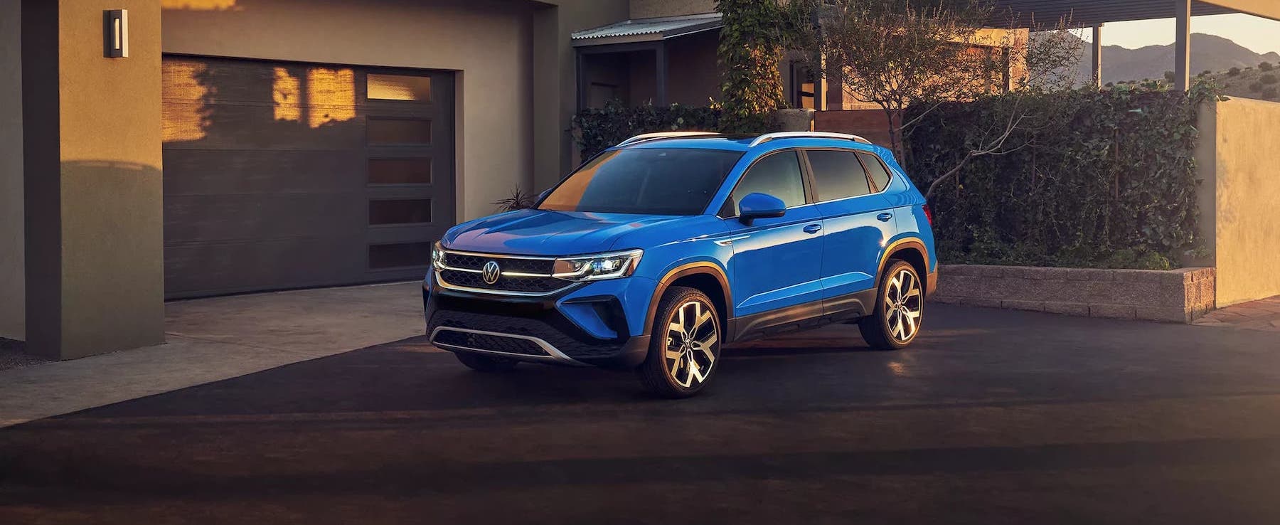 2022 VW Taos in Cornflower Blue outside a modern home