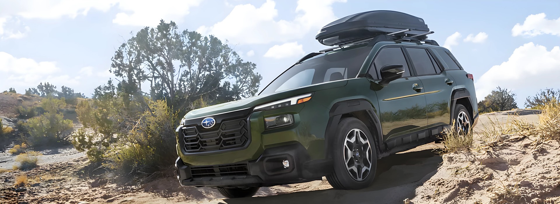 A green 2026 Subaru Outback Wilderness climbing a rocky desert ridge