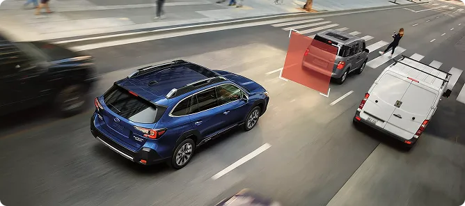 A blue Subaru Outback braking behind a delivery truck in city traffic