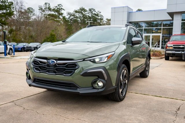 A sage green Subaru Crosstrek parked outside the glass showroom windows at Baldwin Subaru