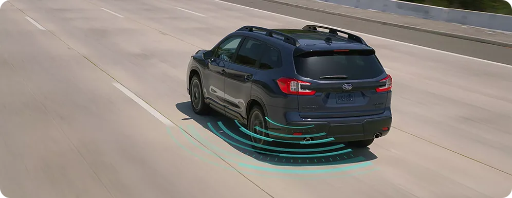 A dark Subaru Outback with blind-spot detection zones highlighted alongside it