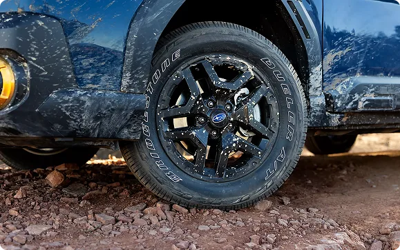 Black alloy wheel with a yellow accent on the Outback Wilderness
