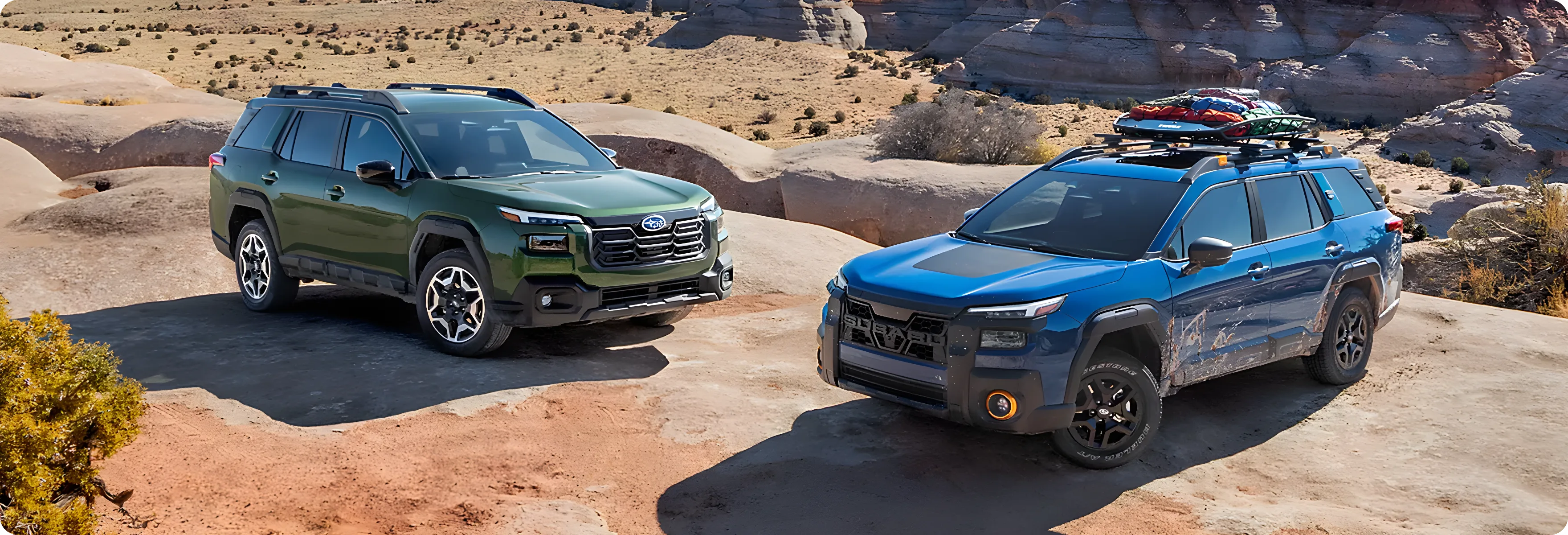 Two 2026 Subaru Outbacks parked among red rock canyon formations