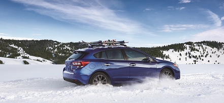 Subaru SUV in snow Subaru SUV driving in snow