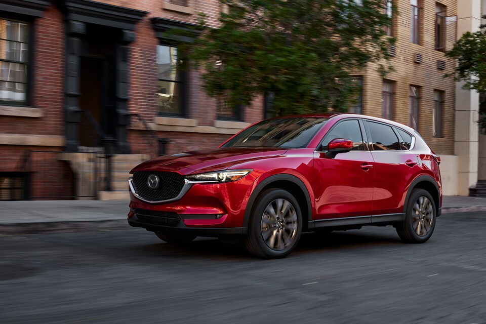Red Mazda CX5 driving in neighborhood bought from Basney Mazda in South Bend.