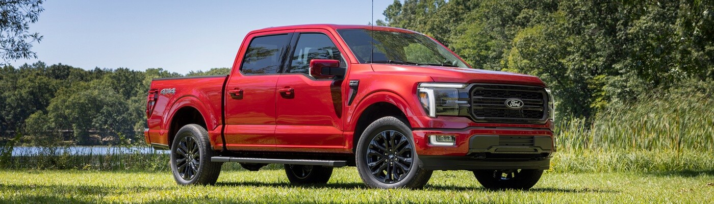 Ford F-150 Red Ford F-150 Lariat Truck parked in a sunny field
