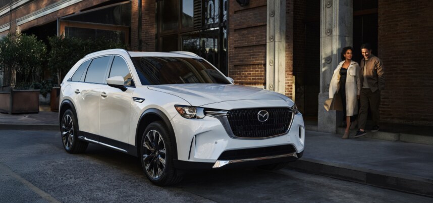 Mazda%20CX-90%20PHEV Mazda CX-90 PHEV parked in an urban setting.