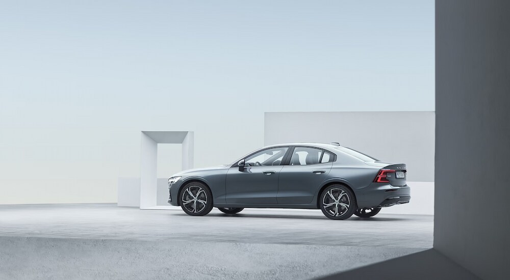 Side view of a silver 2024 Volvo S60 in a showroom.