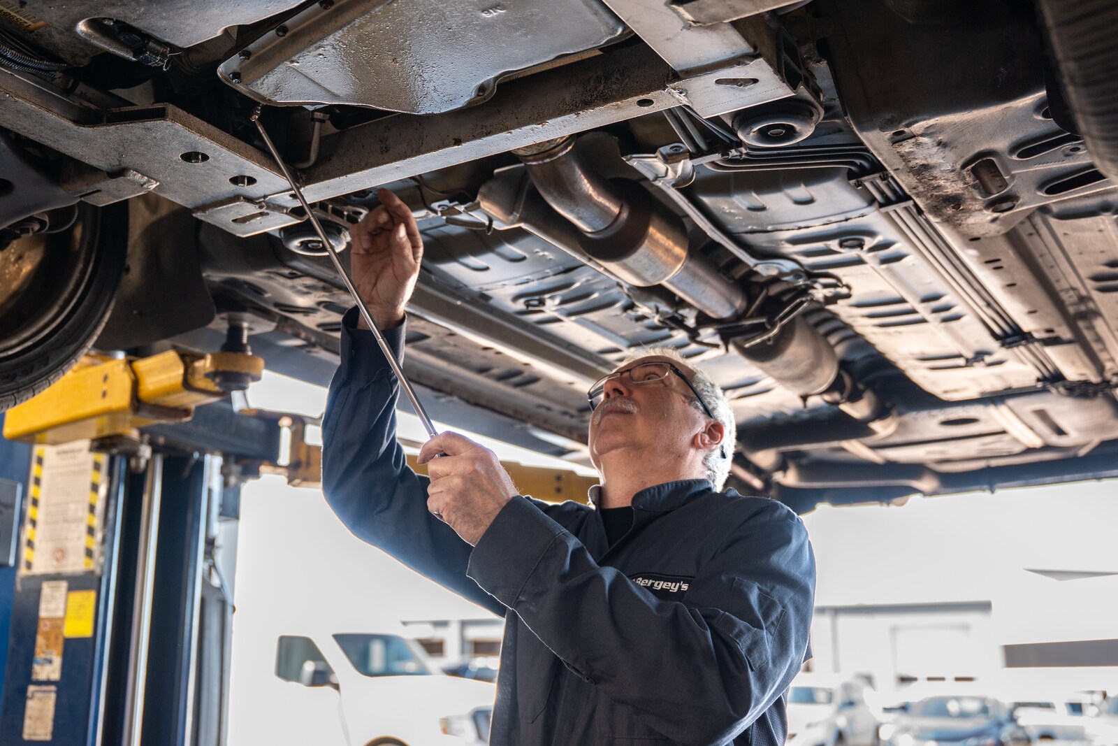 Technician performing additional under-vehicle inspection