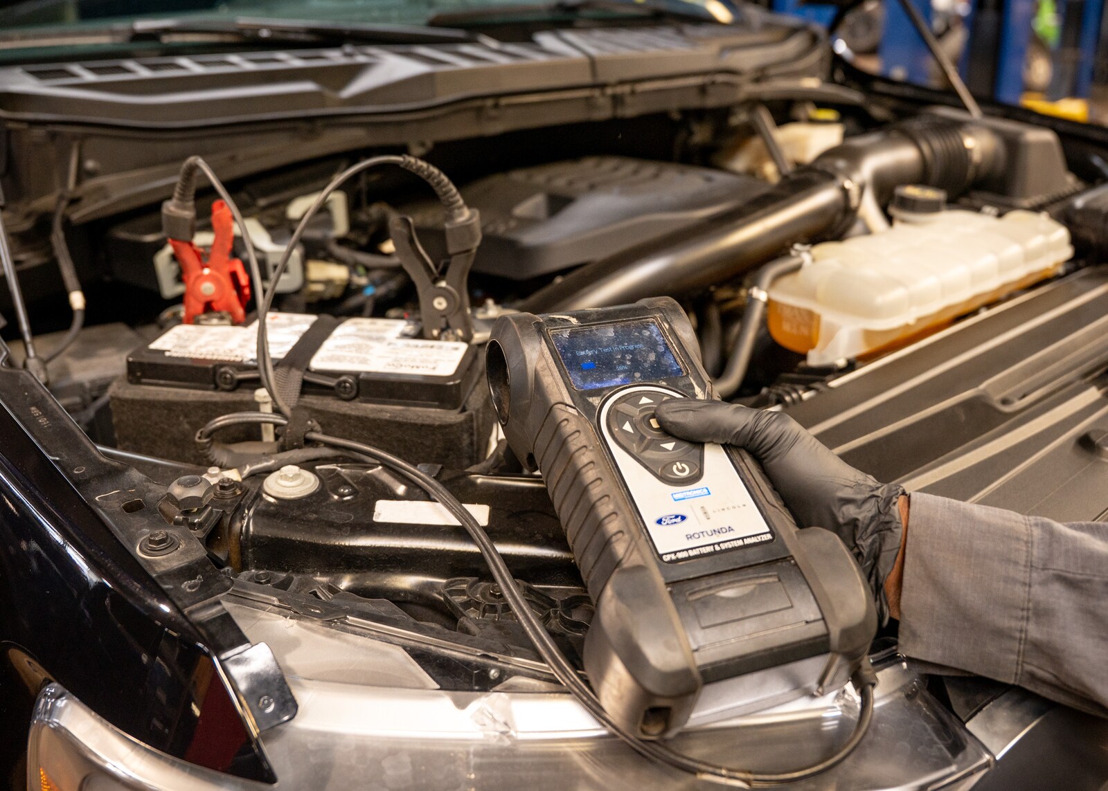 Technician testing a vehicle battery