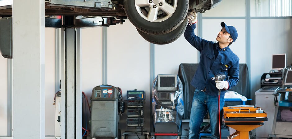 Bill Kay Honda Tire Service A mechanic adjusting the tire alignment on a vehicle