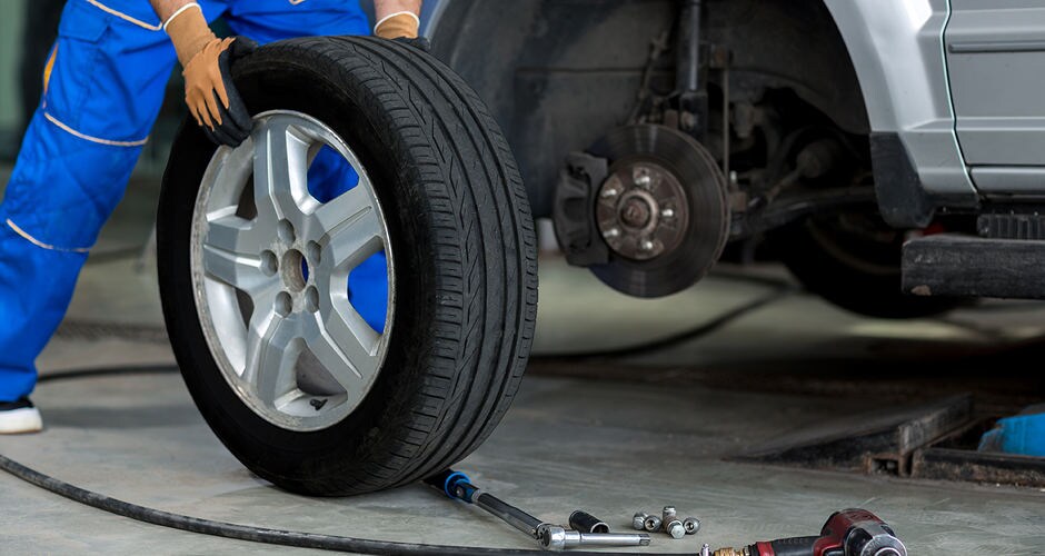 Bill Kay Honda Service Center A man changing a tire on a vehicle