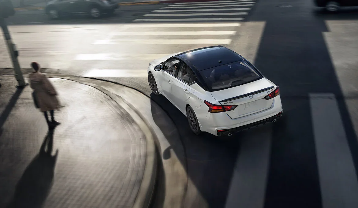 Nissan Altima driving through a city at dusk, the kind of Tacoma commute the WA-512 run replaces