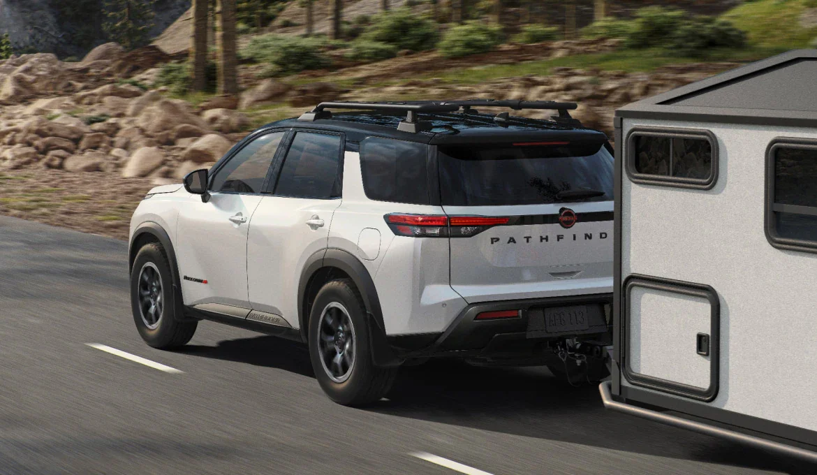 2026 Nissan Pathfinder in silver towing a trailer on a forest road near Lake Tapps, Washington