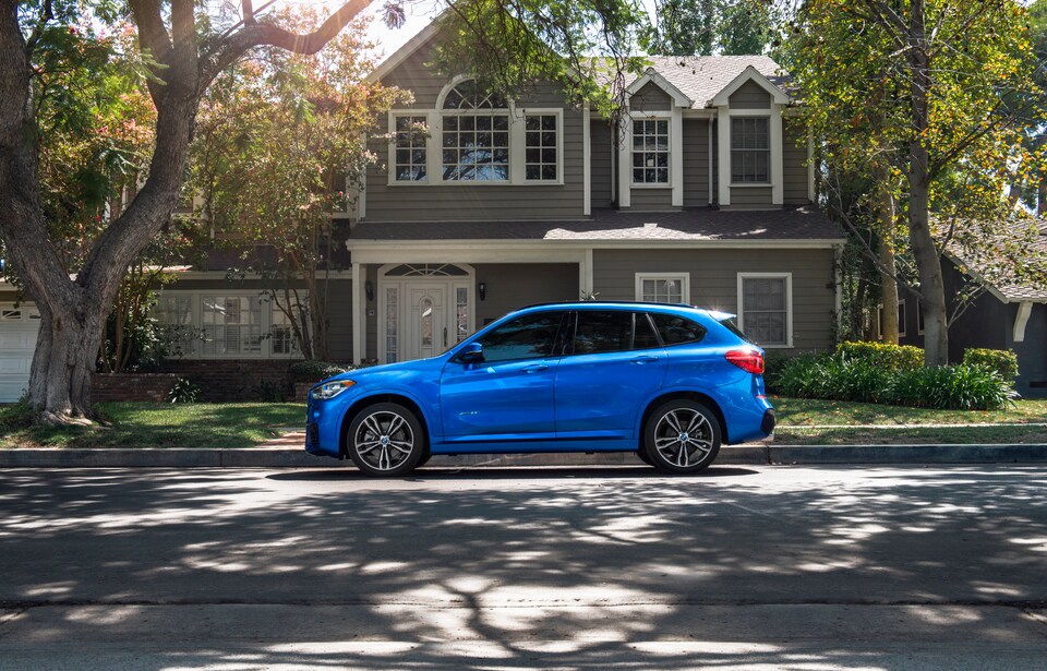 2018 BMW X1 sDrive28i SUV blue by curb in front of house.jpeg